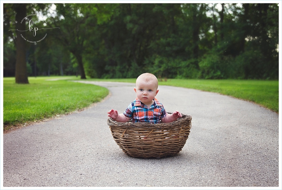 adorable 6 month old boy photo session in green bay wisconsin park sitting in woven basket on trail