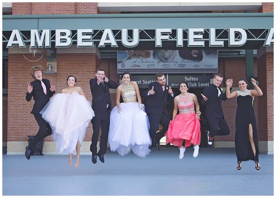 couples jumping for prom pictures at lambeau field in green bay wisconsin