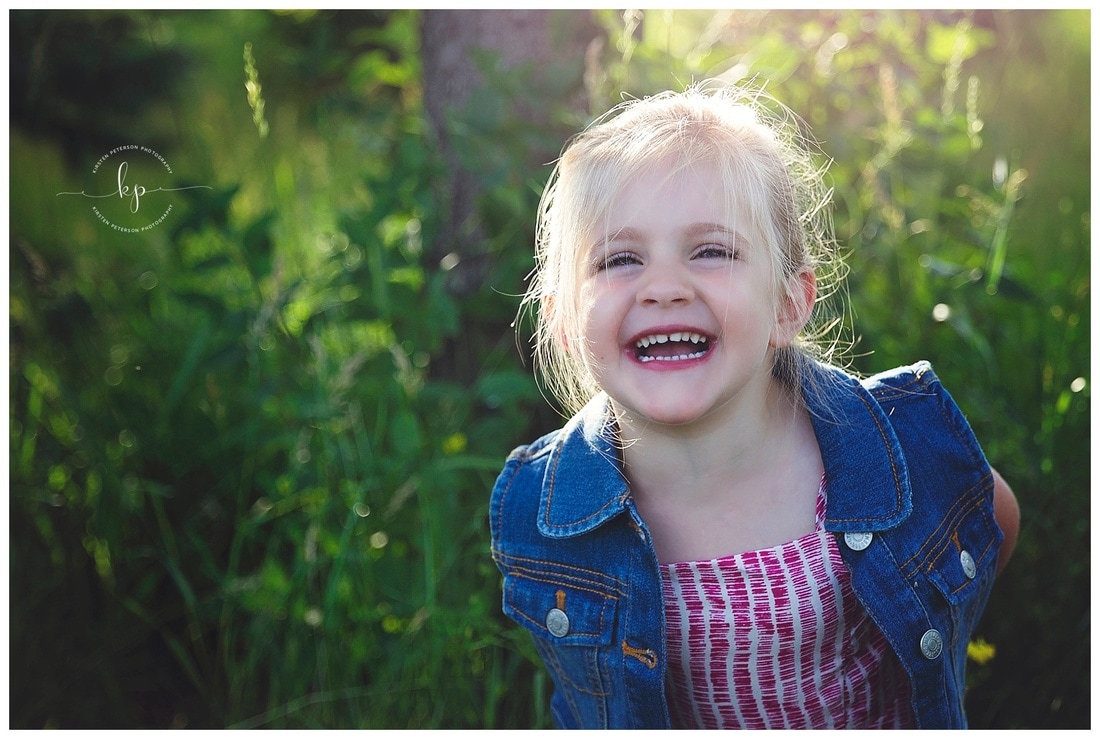 3 year old little girl photography session in green park setting in summer laughing and happy